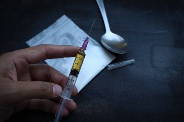 Heroin liquid and heroin powder on a black background, concept of a narcotic substance