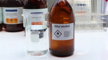 Bardaktaki etil alkol, endüstrideki veya laboratuardaki konteynırlardaki tehlikeli kimyasallar ve semboller 