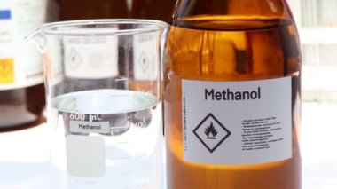 Cam içindeki metanol, tehlikeli kimyasallar ve sanayi veya laboratuvar konteynırlarındaki semboller 