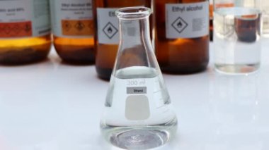 Cam içindeki etanol, tehlikeli kimyasallar ve sanayi veya laboratuvar konteynırlarındaki semboller 