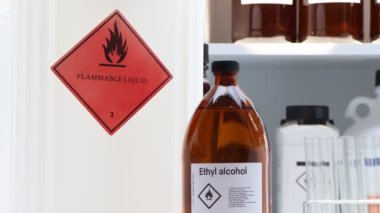 Bardaktaki etil alkol, endüstrideki veya laboratuardaki konteynırlardaki tehlikeli kimyasallar ve semboller 