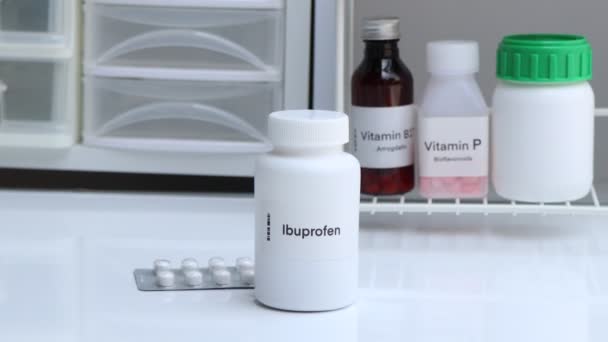 白い瓶 薬の在庫 医療や薬局の概念でイブプロフェン錠剤 — ストック動画