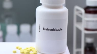 Beyaz şişede metronidazol hapı, ilaç stoku, tıbbi veya eczane konsepti