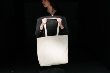 Kentsel şehir arka plan karşı beyaz tekstil eko çanta tutan kadın. Ekoloji veya çevre koruma kavramı. Sahte için beyaz eko çanta.