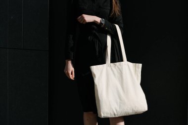 Kentsel şehir arka plan karşı beyaz tekstil eko çanta tutan kadın. Ekoloji veya çevre koruma kavramı. Sahte için beyaz eko çanta.