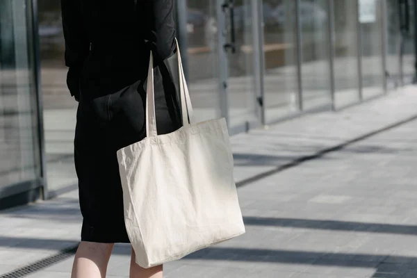 女人拿着白色纺织生态袋在城市背景 生态或环境保护概念 白色生态袋模拟 — 图库照片