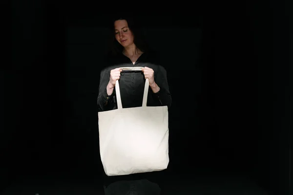 女人拿着白色纺织生态袋在城市背景 生态或环境保护概念 白色生态袋模拟 — 图库照片