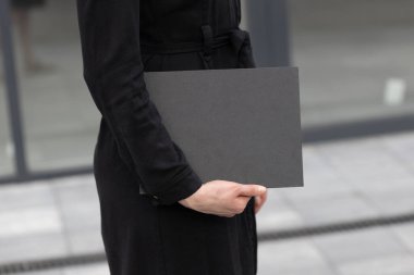 Siyah kitap kapağı bir kadının elinde. Model için kitap kapağı