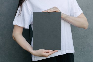 Siyah kitap kapağı bir kadının elinde. Model için kitap kapağı