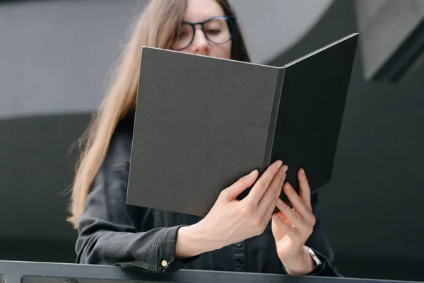 女人手里拿着一本黑色的书 模拟书封面 — 图库照片