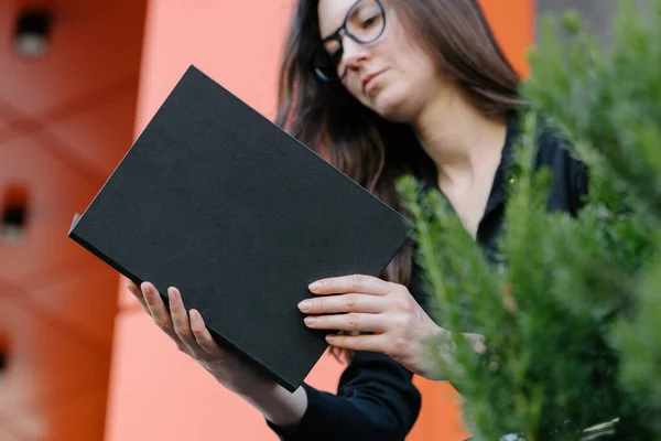 女性の手にブラックブックカバー モックアップのための本カバー — ストック写真