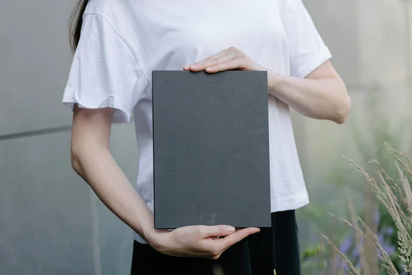 女性の手にブラックブックカバー モックアップのための本カバー — ストック写真