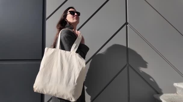 都市環境での女性の手の白いトートバッグまたはエコココットンバッグ — ストック動画