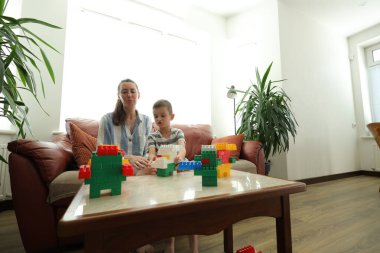 Anne ve çocuk evde oynuyorlar.