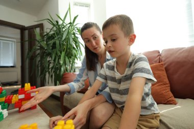 Anne ve çocuk evde oynuyorlar.