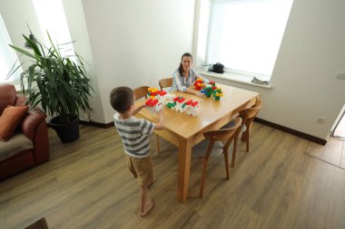 Anne ve çocuk evde oynuyorlar.