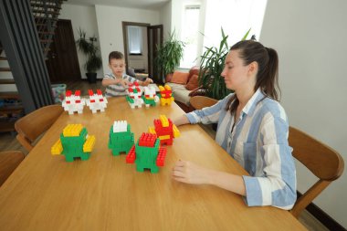 Anne ve çocuk evde oynuyorlar.