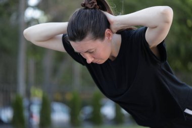 Kadın egzersiz yapıyor ya da dışarıda egzersiz yapıyor.