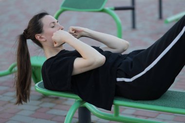 Kadın egzersiz yapıyor ya da dışarıda egzersiz yapıyor.