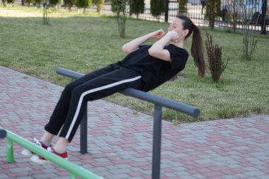 Kadın egzersiz yapıyor ya da dışarıda egzersiz yapıyor.