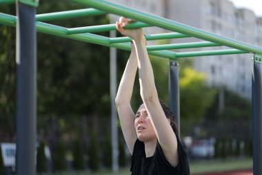 Kadın egzersiz yapıyor ya da dışarıda egzersiz yapıyor.