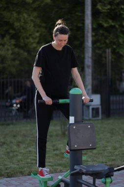 Kadın egzersiz yapıyor ya da dışarıda egzersiz yapıyor.