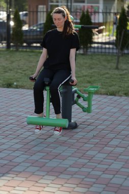 Kadın egzersiz yapıyor ya da dışarıda egzersiz yapıyor.