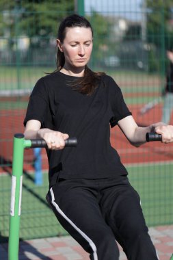 Kadın egzersiz yapıyor ya da dışarıda egzersiz yapıyor.