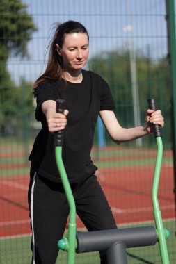 Kadın egzersiz yapıyor ya da dışarıda egzersiz yapıyor.