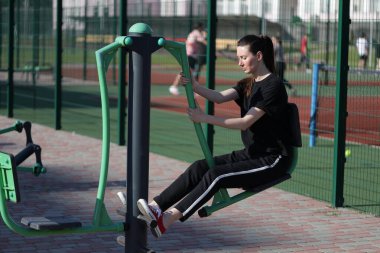 Kadın egzersiz yapıyor ya da dışarıda egzersiz yapıyor.