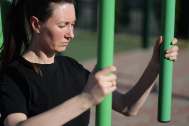 Kadın egzersiz yapıyor ya da dışarıda egzersiz yapıyor.