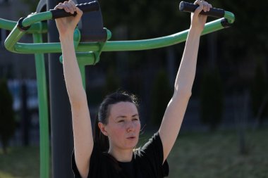 Kadın egzersiz yapıyor ya da dışarıda egzersiz yapıyor.