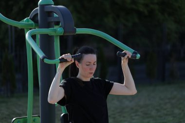 Kadın egzersiz yapıyor ya da dışarıda egzersiz yapıyor.