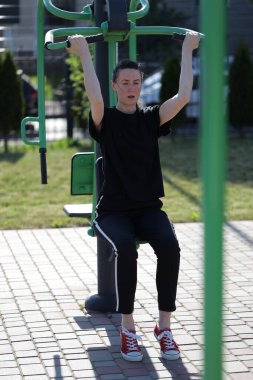 Kadın egzersiz yapıyor ya da dışarıda egzersiz yapıyor.