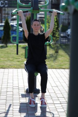 Kadın egzersiz yapıyor ya da dışarıda egzersiz yapıyor.