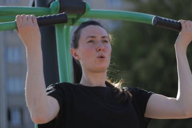 Kadın egzersiz yapıyor ya da dışarıda egzersiz yapıyor.