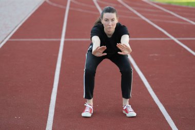 Kadın egzersiz yapıyor ya da dışarıda egzersiz yapıyor.