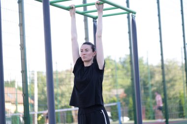 Kadın egzersiz yapıyor ya da dışarıda egzersiz yapıyor.