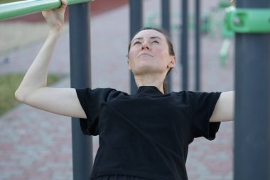 Kadın egzersiz yapıyor ya da dışarıda egzersiz yapıyor.