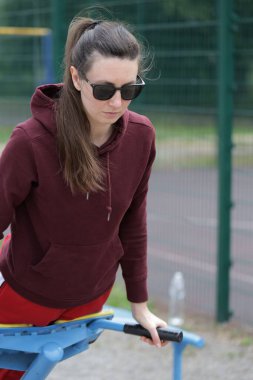 Kadın egzersiz yapıyor ya da dışarıda egzersiz yapıyor.