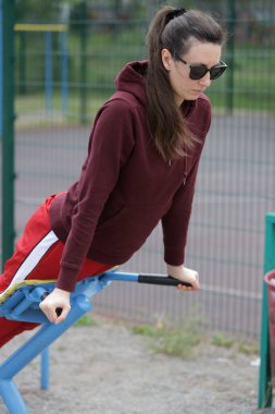 Kadın egzersiz yapıyor ya da dışarıda egzersiz yapıyor.