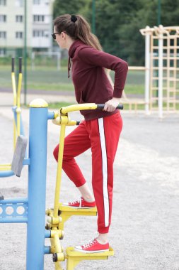 Kadın egzersiz yapıyor ya da dışarıda egzersiz yapıyor.