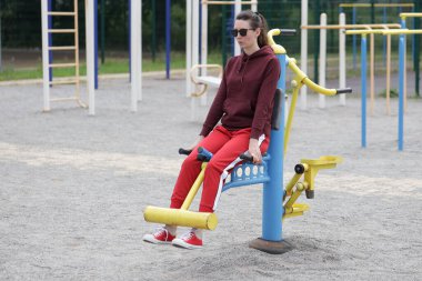 Kadın egzersiz yapıyor ya da dışarıda egzersiz yapıyor.