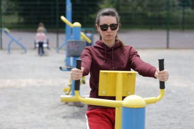 Kadın egzersiz yapıyor ya da dışarıda egzersiz yapıyor.