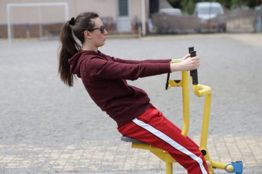 Kadın egzersiz yapıyor ya da dışarıda egzersiz yapıyor.