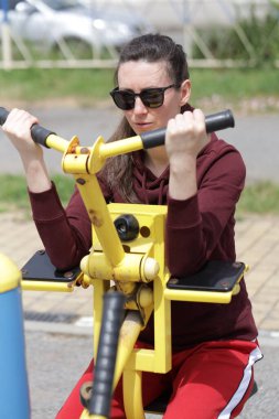 Kadın egzersiz yapıyor ya da dışarıda egzersiz yapıyor.