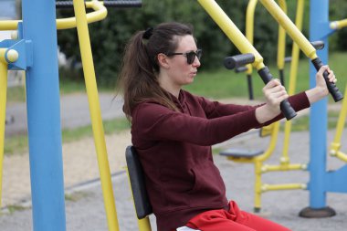 Kadın egzersiz yapıyor ya da dışarıda egzersiz yapıyor.