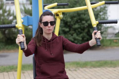 Kadın egzersiz yapıyor ya da dışarıda egzersiz yapıyor.