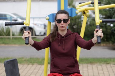 Kadın egzersiz yapıyor ya da dışarıda egzersiz yapıyor.