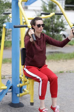 Kadın egzersiz yapıyor ya da dışarıda egzersiz yapıyor.